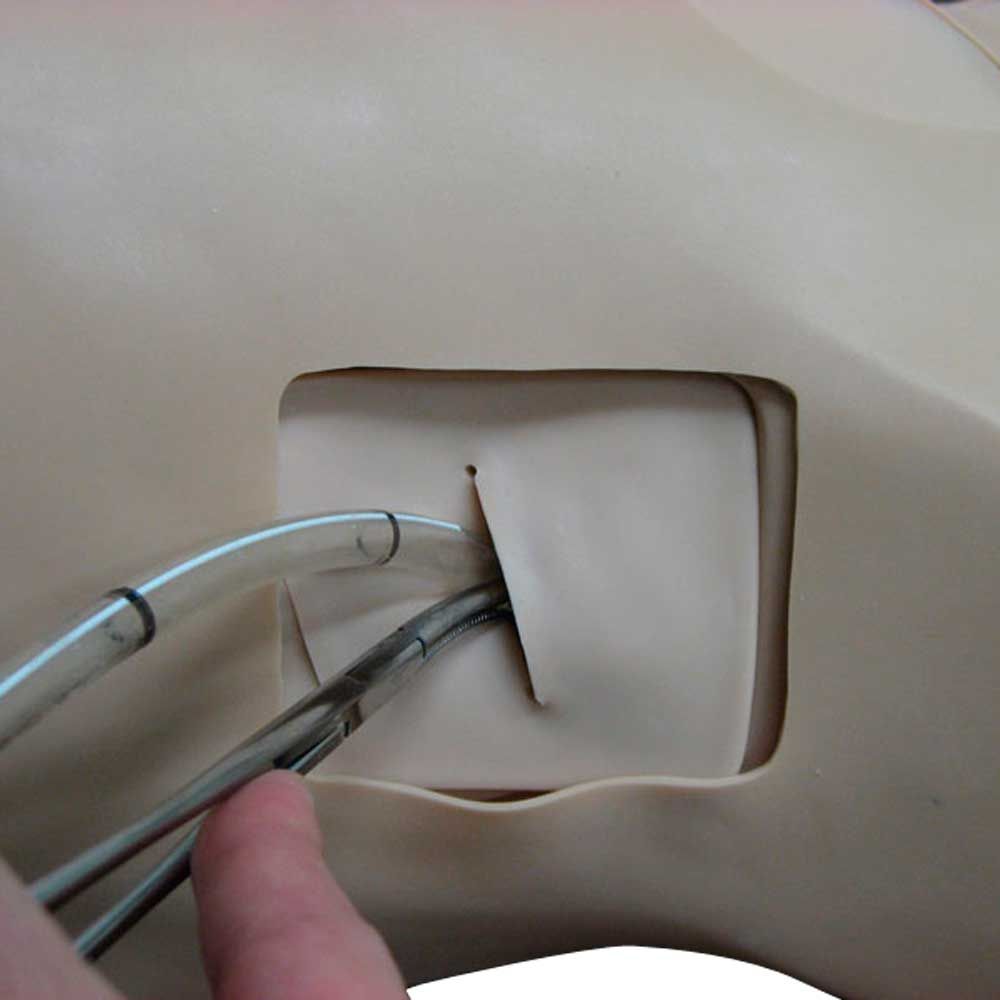 Thorax-Trauma-Simulator, Detail: Instrument und Öffnung an der Brustmarkierung