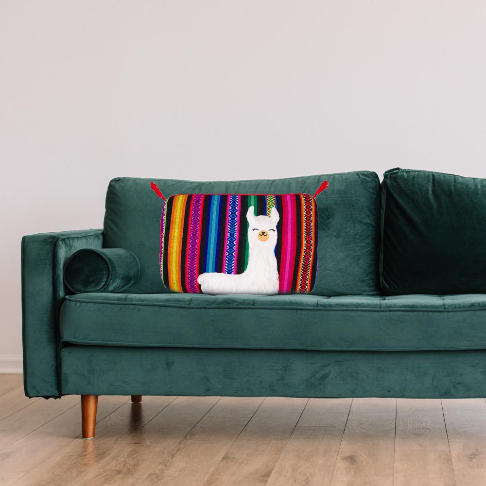 Wärmflasche mit gestreiftem Webstoffbezug und Katzenmotiv, auf dunkelgrünem Sofa